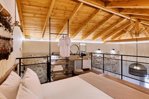 1 dormitorio con cama y techo de madera en Vin Dimora Suites, en Archanes