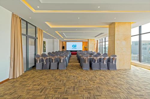 a row of chairs in a conference room with a screen at G8 Luxury Hotel and Spa Da Nang in Da Nang