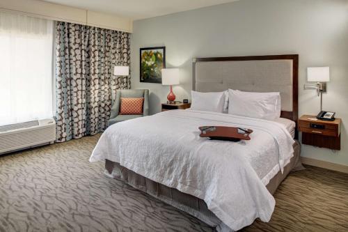 a hotel room with a bed with a suitcase on it at Hampton Inn and Suites by Hilton Vero Beach-Downtown in Vero Beach