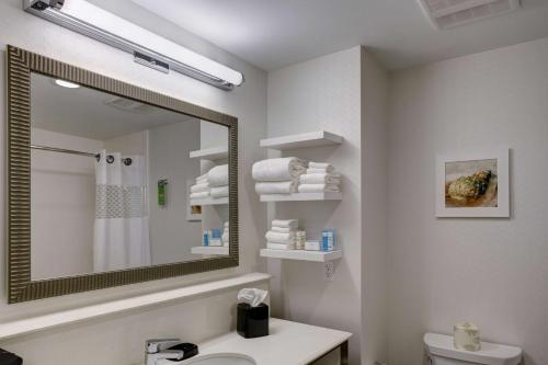 a bathroom with a mirror and a sink and a toilet at Hampton Inn and Suites by Hilton Vero Beach-Downtown in Vero Beach