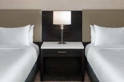 a room with two beds and a lamp on a night stand at Hilton Vancouver Metrotown in Burnaby