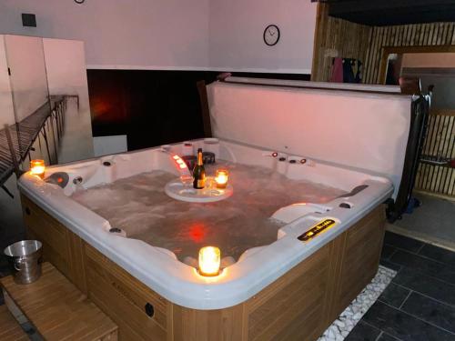 una bañera con velas y luces. en La Villa Audren Love Room Jacuzzi en Châtelaudren