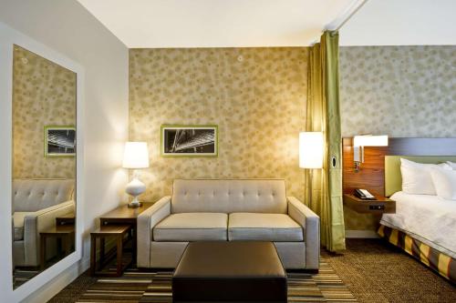 a hotel room with a couch and a bed at Home2 Suites by Hilton Dallas Downtown at Baylor Scott & White in Dallas