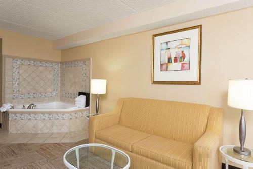 a living room with a couch and a bath tub at Hilton Garden Inn West Lafayette Wabash Landing in Lafayette