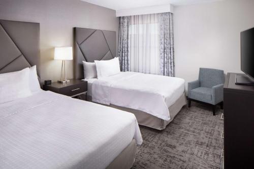 a hotel room with two beds and a chair at Homewood Suites by Hilton Atlanta Lenox Buckhead in Atlanta