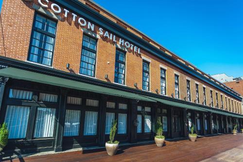 a large brick building with potted plants in front of it at The Cotton Sail Hotel Savannah - Tapestry Collection by Hilton in Savannah