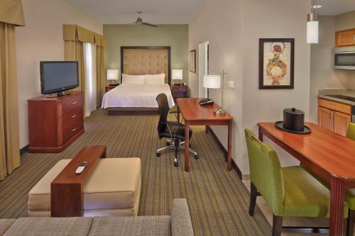 a hotel room with a bed and a desk at Homewood Suites by Hilton Daytona Beach Speedway-Airport in Daytona Beach