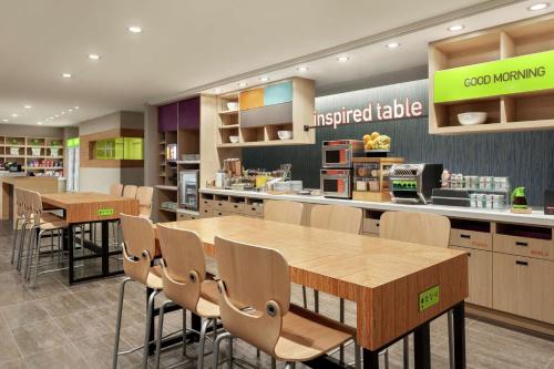 a kitchen with wooden tables and chairs in a store at Home2 Suites By Hilton Silver Spring in Silver Spring