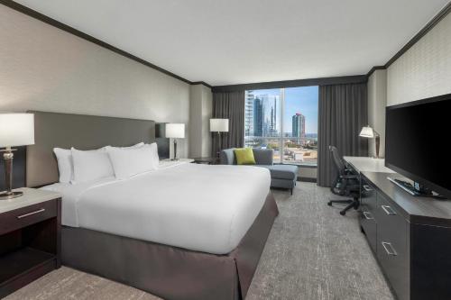 una camera d'albergo con un grande letto e una TV di Hilton Vancouver Metrotown a Burnaby