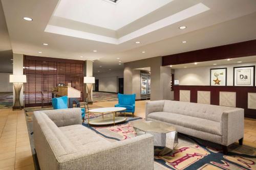 a lobby with two couches and a table and blue chairs at DoubleTree by Hilton DFW Airport North in Irving