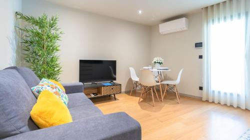 a living room with a couch and a tv and a table at Casa do Canal de Sao Roque in Aveiro