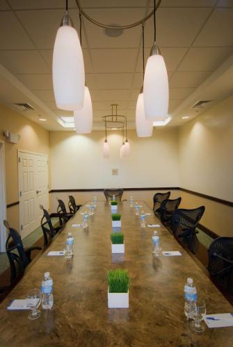 a long table in a room with chairs and lights at Hilton Garden Inn Dulles North in Ashburn