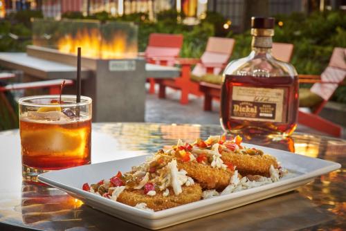 a plate of food on a table with a bottle of whiskey at Hilton Knoxville in Knoxville