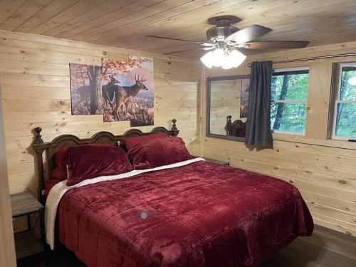 a bedroom with a bed with a red comforter at Creekside 3 bedroom 2 bath cabin on private creek in Banner Elk
