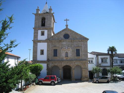 an old church with a tower with a clock on it at Anjú-Pardal in Mogadouro