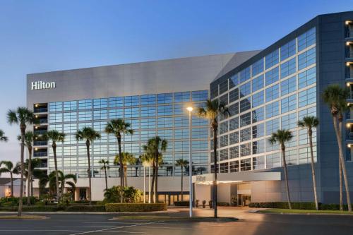 an office building with palm trees in front of it at Hilton Melbourne in Melbourne