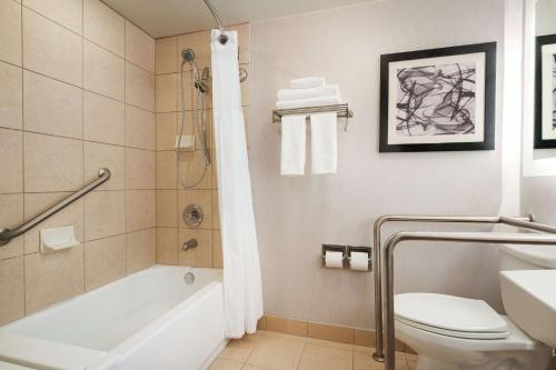 a bathroom with a tub and a toilet and a sink at Hilton Melbourne, FL in Melbourne