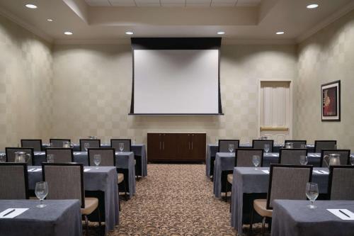 a conference room with tables and chairs and a projection screen at Hilton Melbourne, FL in Melbourne
