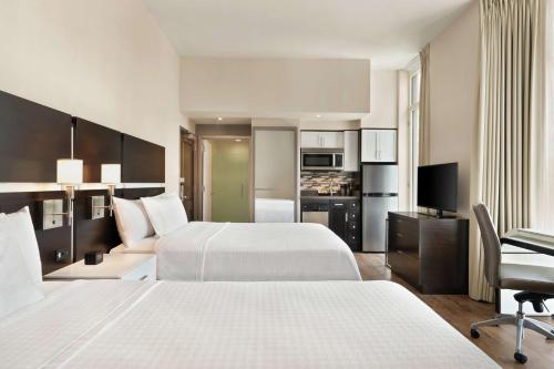 a hotel room with two beds and a television at Homewood Suites Midtown Manhattan Times Square South in New York