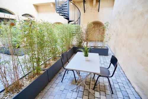 einen Tisch und Stühle auf einer Terrasse mit Pflanzen in der Unterkunft Le Chana - Atypique 3 pers -Terrasse-St Paul in Lyon