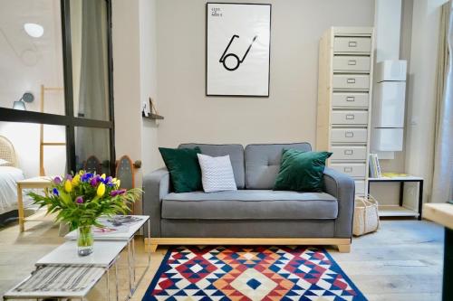 ein Wohnzimmer mit einem Sofa und einem Tisch in der Unterkunft Le Chana - Atypique 3 pers -Terrasse-St Paul in Lyon