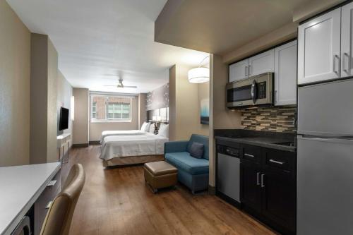 a room with a kitchen and a bedroom with a bed at Homewood Suites Midtown Manhattan Times Square South in New York