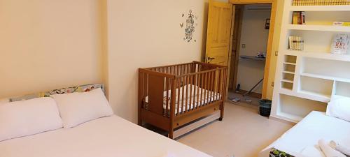 - une chambre avec 2 lits et un lit bébé dans l'établissement Villa Elli, à Alexandroúpolis