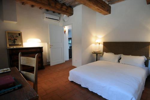 a bedroom with a large white bed and a desk at Fattoria il Leccio Fienile on Florence Hills in Fiesole