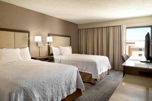 a hotel room with two beds and a television at Hampton Inn Philadelphia/Mt. Laurel in Mount Laurel