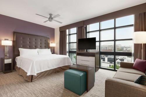 a bedroom with a bed and a tv and a couch at Homewood Suites by Hilton Washington DC Convention Center in Washington, D.C.