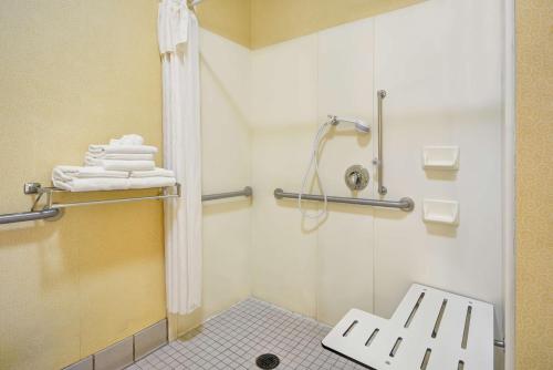 オークランドにあるホームウッド スイーツ バイ ヒルトン オークランド ウォーターフロントのバスルーム(シャワー、ベンチ、タオル付)