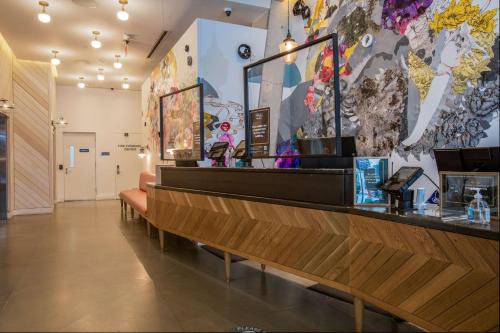 a restaurant with a bar with benches and paintings on the wall at Motto by Hilton Washington DC City Center in Washington