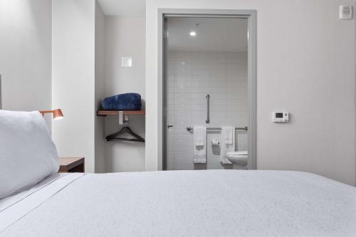 a bedroom with a bed and a bathroom with a toilet at Motto by Hilton Washington DC City Center in Washington, D.C.