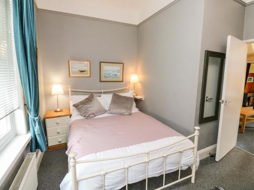 a bedroom with a bed and two lamps and a window at Flat 1 in Teignmouth