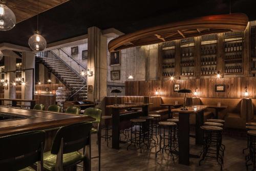 a restaurant with tables and chairs and a staircase at Motto by Hilton Washington DC City Center in Washington