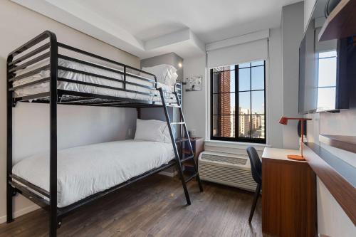 a small room with a bunk bed and a desk at Motto by Hilton Washington DC City Center in Washington