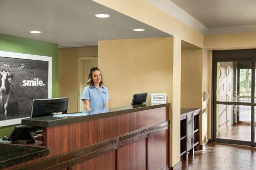 a woman standing at the reception desk of a dental office at Hampton Inn Portland Airport in Portland