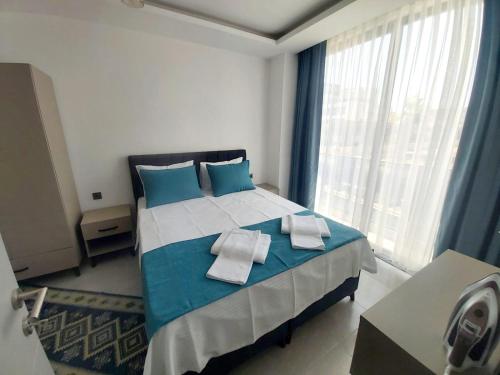 Un dormitorio con una cama azul y blanca con toallas. en Ethica Suite Luxury Houses en Aksu