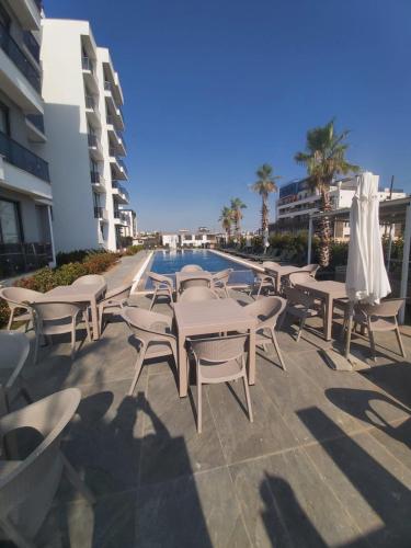 a group of tables and chairs next to a swimming pool at Ethica Suite Luxury Houses in Aksu