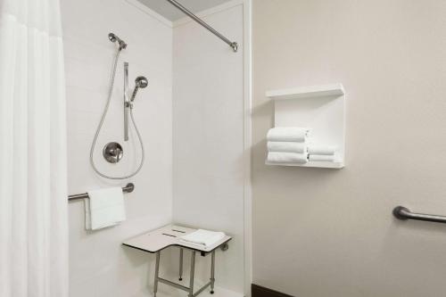 a bathroom with a shower and a toilet with towels at Hampton Inn Portland Airport in Portland