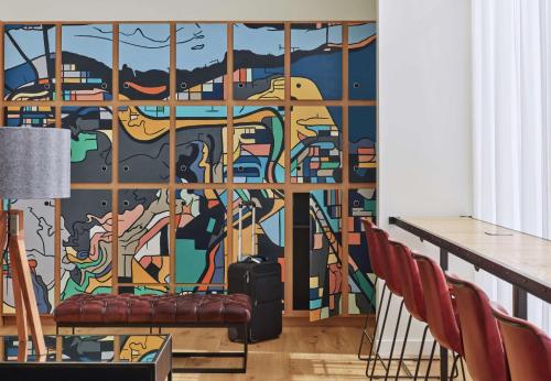 a mural in a room with a table and chairs at Canopy by Hilton Portland Pearl District in Portland