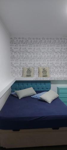 a bedroom with a blue bed with pillows on it at Sitio Chacara temporada Lindoia Villa Vale in Lindóia