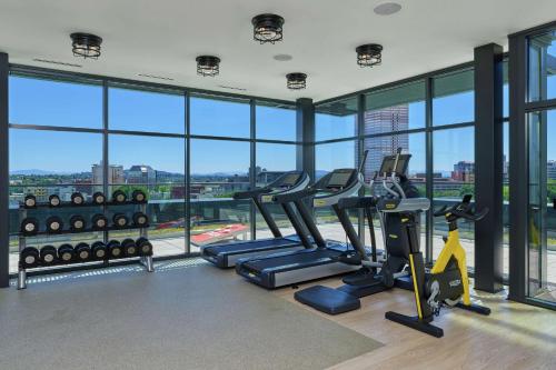 a gym with cardio machines in a building with windows at Canopy by Hilton Portland Pearl District in Portland