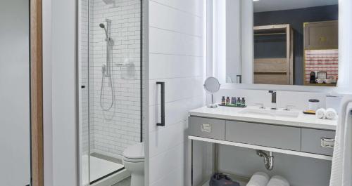a white bathroom with a shower and a sink at Canopy by Hilton Portland Pearl District in Portland