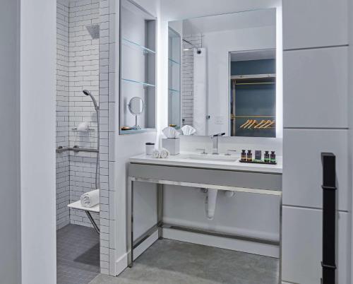 a white bathroom with a sink and a mirror at Canopy by Hilton Portland Pearl District in Portland
