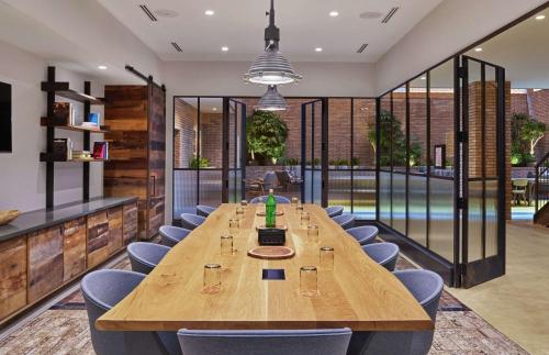 une salle de conférence avec une grande table et des chaises en bois dans l'établissement Canopy by Hilton Portland Pearl District, à Portland