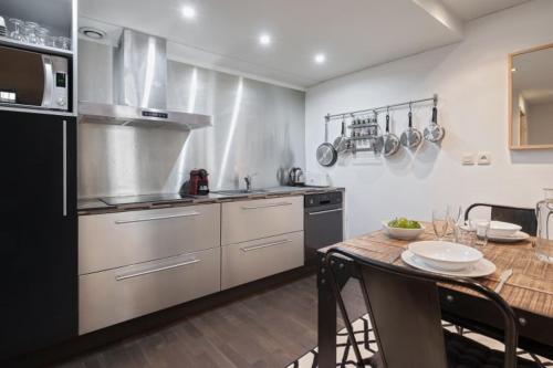 une grande cuisine avec une table et un comptoir dans l'établissement GuestReady - Superbe Maison de ville Duplex, à Lyon