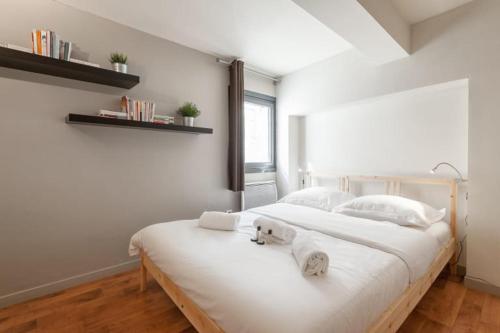 une chambre avec un grand lit blanc avec des serviettes dessus dans l'établissement GuestReady - Superbe Maison de ville Duplex, à Lyon