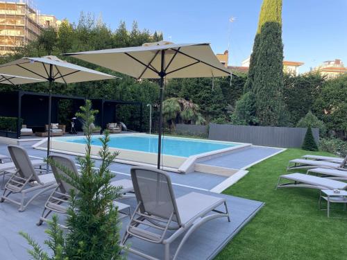 - une piscine avec des chaises et des parasols dans une cour dans l'établissement Mh Florence Hotel & Spa, à Florence