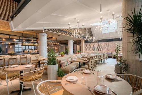 a restaurant with tables and chairs and a bar at Motto by Hilton Philadelphia Rittenhouse Square in Philadelphia